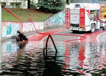 temporale estivo in Italia con strade allagate e alberi piegati dal vento